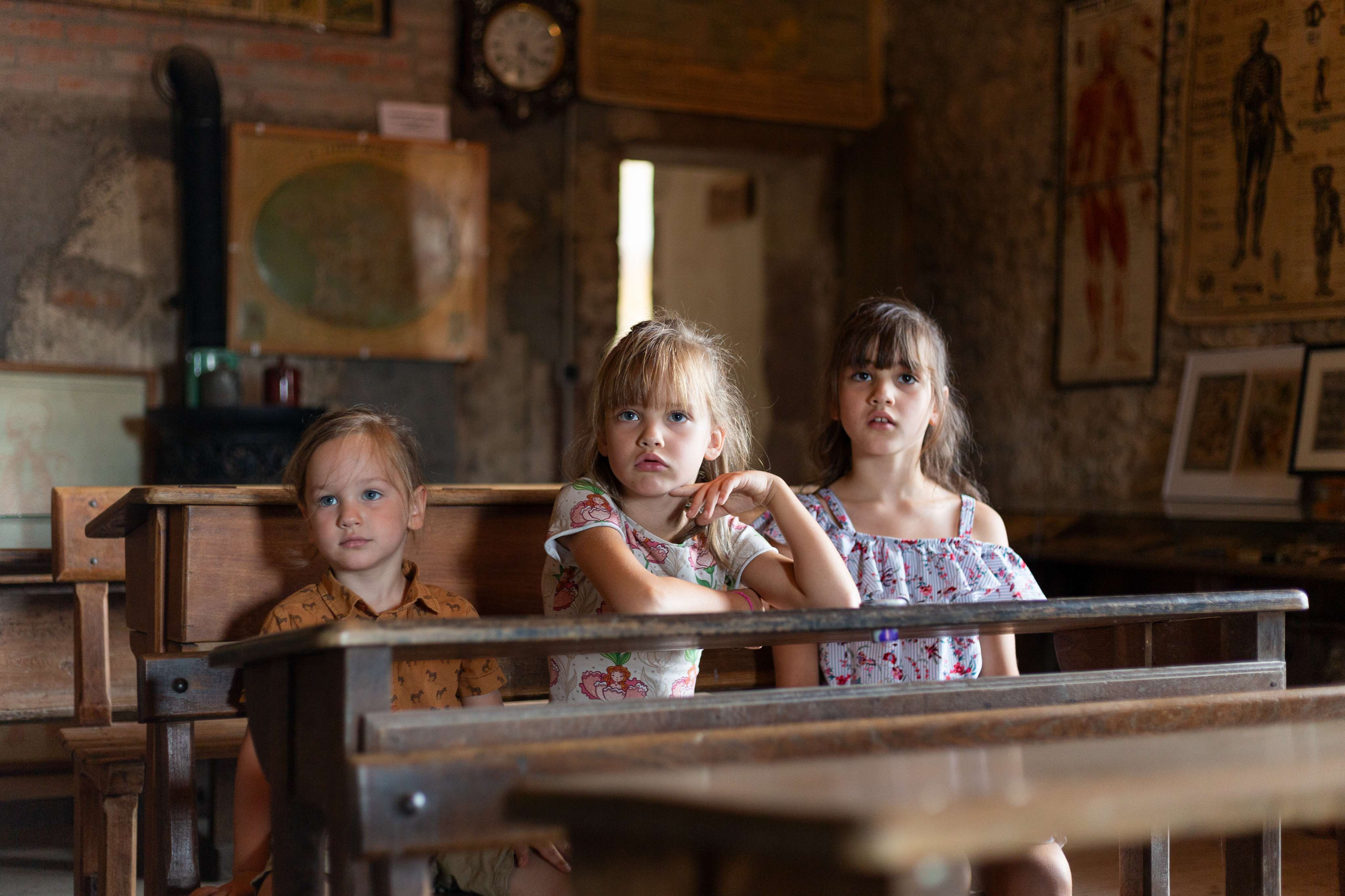 Des enfants à la découverte de la salle de classe ancienne