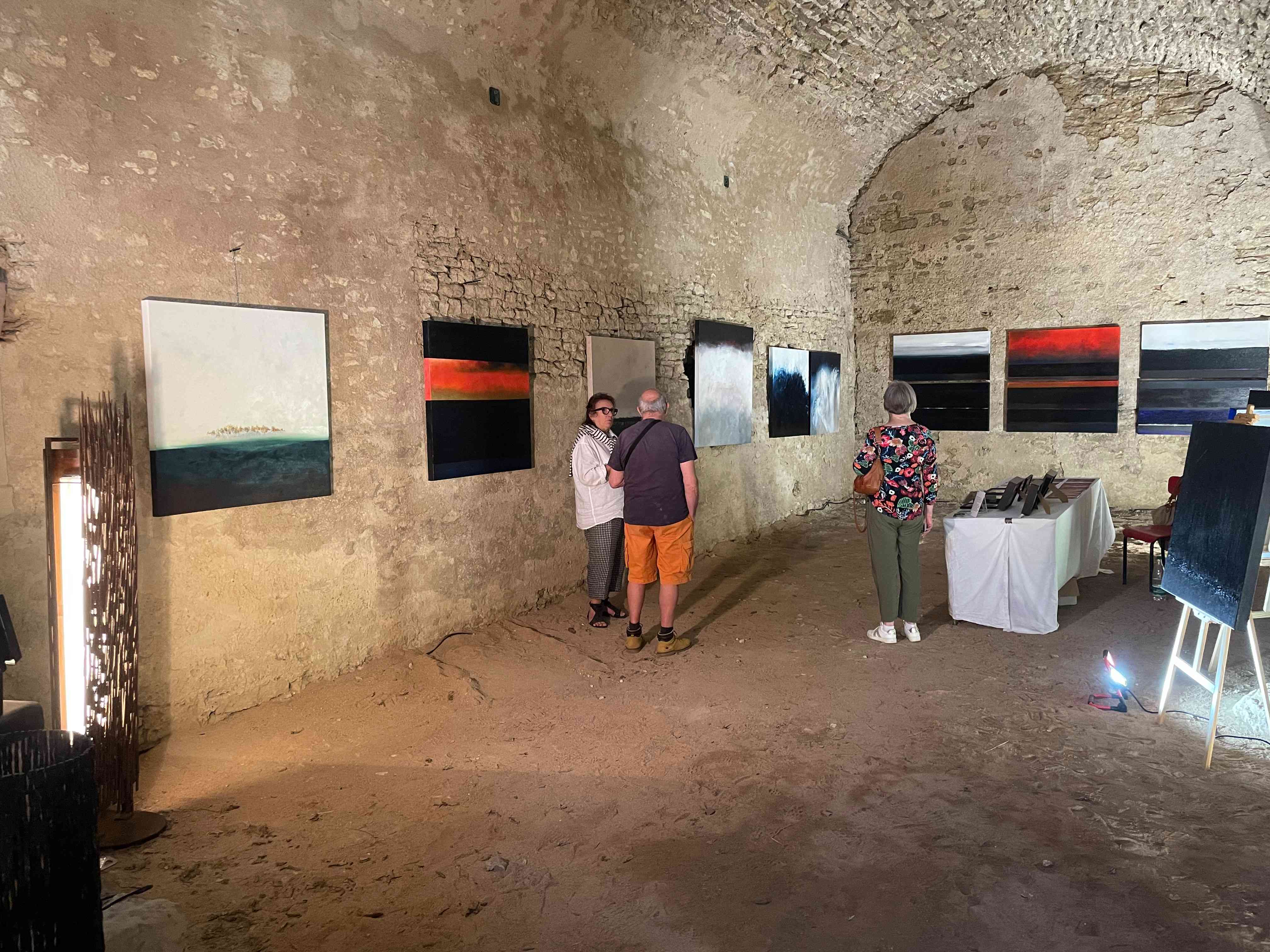 Visiteurs devant les peintures de l'exposition « Artypique »